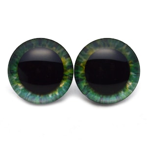 May include: Two green and black plastic safety eyes for crafts. The eyes have a black pupil and a green iris with a yellow ring around the pupil.