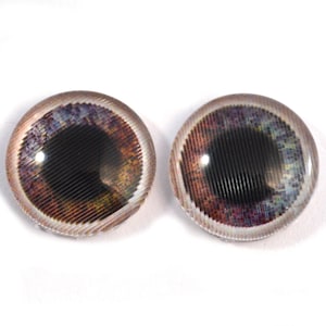 Könnte beinhalten: Zwei runde Puppenaugen aus Glas mit einer detaillierten, mehrfarbigen Iris. Die Iris zeigt Brauntöne, Lila und Blau mit einer schwarzen Pupille. Sie haben ein strukturiertes, geriffeltes Muster und einen klaren, abgerundeten Rand.
