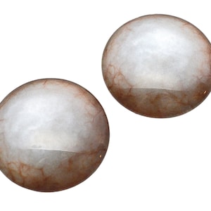 May include: Two round, translucent, light-colored orbs with a network of reddish-brown veins visible beneath the surface. The orbs have a glossy finish and are set against a plain white background.