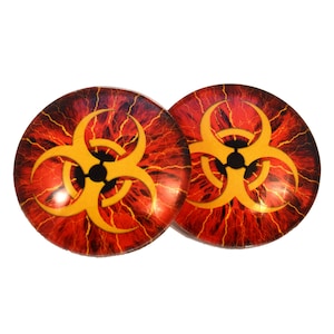 Puede incluir: Dos tapones redondos decorativos con un símbolo de peligro biológico. Los tapones tienen un fondo rojo y naranja con un símbolo amarillo de peligro biológico en el centro. El diseño evoca una erupción volcánica.