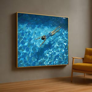 Puede incluir: Una pieza de arte mural rectangular que presenta una vista cenital de una persona nadando en agua de piscina azul brillante. La obra muestra la luz reflejándose en la superficie del agua, creando patrones de azul, turquesa y blanco.