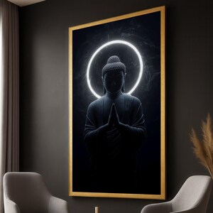 以下が含まれることがあります： 祈りのポーズの暗い灰色の仏像が特徴の額装されたアートワーク。明るい白い光輪が黒い背景に対して仏陀の頭を囲んでいます。フレームは金色です。瞑想に適しています。