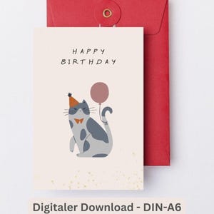 May include: A birthday greeting card featuring a whimsical illustration of a gray and white cat wearing a party hat and bow tie, holding a balloon. The words "HAPPY BIRTHDAY" are printed above the cat. The card is paired with a red envelope.