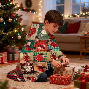 May include: A patchwork hooded blanket featuring a repeating pattern of Christmas-themed squares with hearts, snowflakes, and stockings. The blanket has a personalized touch with multiple faces printed on the squares. The blanket is draped over a person opening gifts.