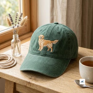 Può includere: Un berretto da baseball verde bosco con un golden retriever ricamato sul pannello frontale. Il berretto presenta una corona strutturata, una visiera curva con cuciture tono su tono e occhielli per la ventilazione sulla parte superiore.