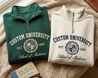 Sudadera personalizada con cremallera de un cuarto de la Facultad de Medicina de la Universidad.