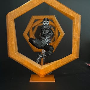 May include: A black and white Spider-Man action figure is positioned within a series of orange hexagonal frames. The figure is in a dynamic pose, with the frames creating a sense of depth and movement. The overall theme is superhero collectibles.