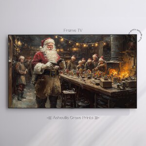May include: A framed print depicting Santa Claus in his workshop, surrounded by elves. Santa, in a red suit and hat, examines an object. The workshop is filled with toys and a warm fire. The text "Frame TV" and "Asheville Grove Prints" are visible.
