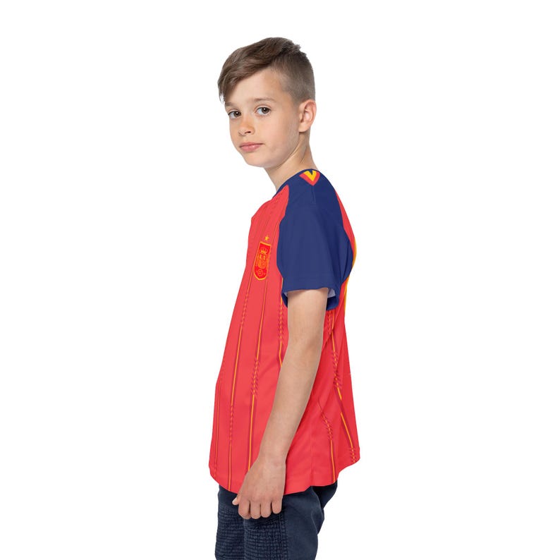 May include: A red and yellow striped jersey with blue sleeves. The jersey features a crest on the chest and is worn by a person. The jersey is likely a sports uniform, possibly for soccer or another team sport.