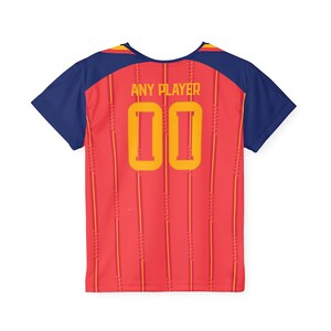 May include: Red and yellow soccer jersey with the text "ANY PLAYER" and the number "00" in yellow. The jersey has navy blue sleeves and a yellow and navy blue neckline. Vertical yellow stripes run down the back of the jersey.