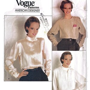 Könnte beinhalten: Vogue Patterns American Designer Schnittmuster 1230 von Calvin Klein. Die Hülle zeigt drei Varianten von langärmeligen Blusen: eine Satinbluse mit hohem Kragen, eine Bluse mit Kragen und Brusttasche sowie eine Bluse mit seitlicher Schleife.