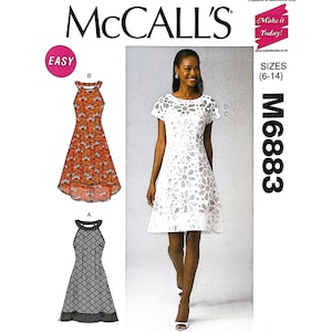 May include: McCall's sewing pattern M6883. The image shows three dress designs: a white dress with floral cutouts, a black and white patterned dress, and an orange floral dress. The pattern is marked "EASY" and includes sizes 6-14.