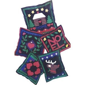 May include: A selection of handmade Christmas felt decorations. Each square ornament has a unique design, including a house with the word "HOME", a wreath, the word "NOEL", a reindeer, and hearts. The ornaments are mainly navy blue, red, green, and yellow.