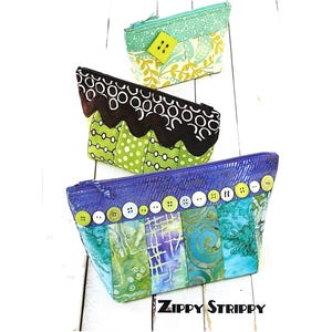 May include: Three handmade fabric zipper pouches in shades of green, blue, and brown. The pouches feature decorative buttons and patterned fabric. The bottom pouch has the text "ZIPPY STRIPPY".