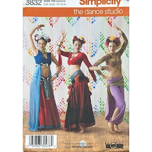 May include: Simplicity 3832 sewing pattern for dance costumes. The envelope features three outfits: a blue top with a sheer blue skirt over a red skirt, a red long-sleeve top with a dark skirt, and a gold-toned top with purple harem pants.