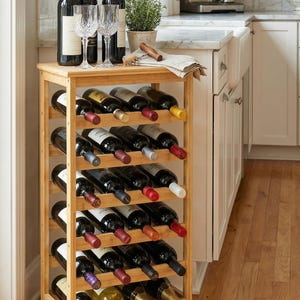 May include: A bamboo wine rack holding multiple bottles of wine, with wine glasses and bottles on top. The rack has multiple shelves to store the wine bottles horizontally. The wine bottles have various colored labels and corks.