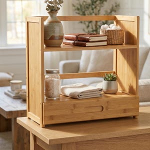 Bamboo countertop organizer with drawer styled with books, vase, and small decor items on a table.