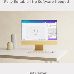 Puede incluir: Un monitor de computadora dorado que muestra un dise&ntilde;o con las letras "AR" y la palabra "aurora". Tambi&eacute;n se ve el texto "Fully Editable | No Software Needed" y "Just Canva!". Un teclado, un rat&oacute;n y jarrones blancos est&aacute;n sobre el escritorio blanco.
