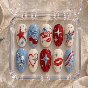 May include: A set of ten press-on nails in a clear plastic case, featuring red, white, and blue designs. Patterns include a red star, cherries with a blue bow, the text AMERICAN GIRLS with a lip print, a disco ball, a heart, and striped accents.