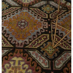 Alfombra de lana anudada a mano con diseño geométrico tribal en color marrón óxido, con patrón de medallón de diamante, estilo étnico tradicional, ideal para sala de estar o dormitorio.