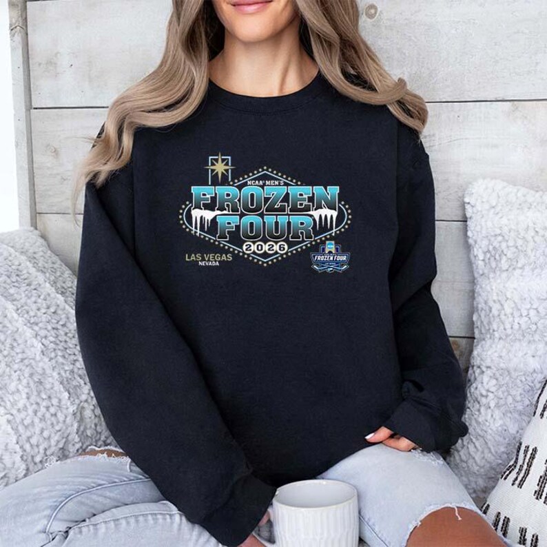Op de afbeelding: Een marineblauw sweatshirt met de tekst "FROZEN FOUR 2026" in een gestileerd ontwerp met lichtblauwe en witte kleuren. Het sweatshirt bevat ook de tekst "Las Vegas Nevada" en een klein logo.