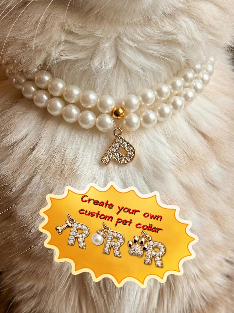 May include: A double-strand white faux pearl pet collar featuring a gold-toned letter P charm encrusted with clear crystals. A yellow graphic overlay displays the text Create your own custom pet collar with additional letter R and charm options.