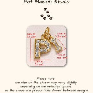 May include: A gold-toned letter P charm encrusted with clear crystals, paired with a small gold-toned bone charm. The letter P measures 0.66 inches by 0.47 inches, and the bone charm measures 0.55 inches by 0.19 inches. Text reads Pet Maison Studio.