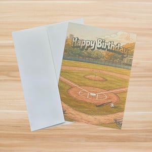 May include: A birthday card with a baseball field illustration and the words "Happy Birthday" in a vintage font. The card is accompanied by a white envelope, perfect for sending birthday wishes to a baseball fan.