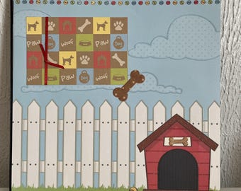 May include: A scrapbook page with a dog theme. It features a white picket fence, a red dog house, and a blue sky with clouds. The page includes a grid with dog-related icons and the words "Paw," "Dog," and "Woof."
