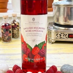 Könnte beinhalten: Eine durchsichtige Kunststoffflasche gefüllt mit tiefrotem English Mulberry köchelndem Flüssig-Potpourri. Das Etikett zeigt den Markennamen Ambria, Text auf Englisch und Französisch sowie eine Grafik roter Beeren. Die Flasche enthält 472 ml.
