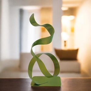 Op de afbeelding: Een moderne, abstracte sculptuur in een levendige groene tint. Het metalen kunstwerk heeft een vloeiend, lintachtig ontwerp dat omhoog draait en buigt vanaf een rechthoekige basis. Een decoratief accentstuk.