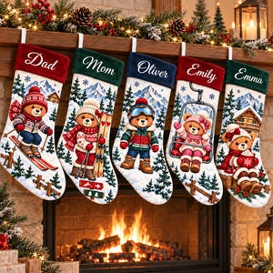 May include: Five white Christmas stockings with plush cuffs in red, green, and blue. Each features a winter scene with teddy bears and names embroidered in white: Dad, Mom, Oliver, Emily, and Emma. The bears are skiing, riding a ski lift, or relaxing in the snow.
