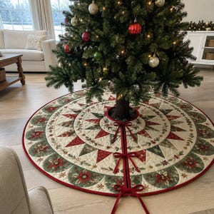 May include: A circular quilted Christmas tree skirt featuring a cream-colored base with a red and green star pattern, poinsettia floral motifs, and a red border. The skirt includes three red ribbon ties for closure around the tree trunk base.
