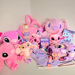 May include: A selection of pink and purple Lilo & Stitch themed items. The image shows plush toys, a water bottle, a pencil case, stickers, a notepad, and a small building block set. The plush toys are in various sizes and designs, some with long ears.