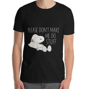 May include: Black t-shirt featuring a graphic of a cartoon dog lying down with the text "PLEASE DON'T MAKE ME DO STUFF" in white. The dog is white with black accents. The shirt is made of a soft material.