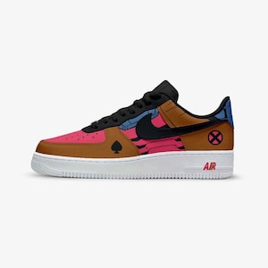 May include: A low-top sneaker featuring a brown and pink color scheme with black accents. The side displays a black spade symbol and a circular pink X logo. A black Nike swoosh is on the side, and the white midsole features the word AIR in red.