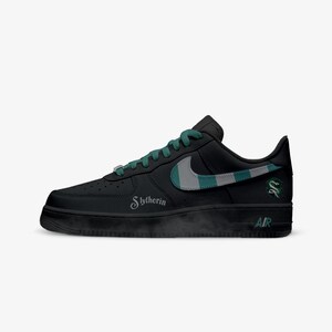May include: Black sneaker with green and gray accents. Features the word "Slytherin" and a snake emblem. The Nike swoosh is gray and green. The laces are green. The word "AIR" is printed on the sole.
