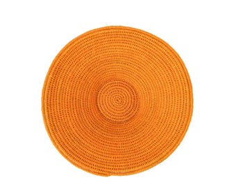 Peut inclure: Un set de table circulaire tissé en orange vif, présentant un motif dense de bobines concentriques. La texture est uniforme et étroitement construite, créant une surface plate et ronde avec une teinte orange vive et cohérente.