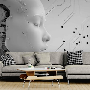 May include: A monochrome wall mural depicting a large, stylised robotic face with closed eyes. The background features circuit board patterns. A grey sectional sofa with cushions and a wooden coffee table are in front of the mural.