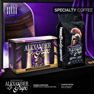 May include: A black bag and box of "Alexander Le Grape" specialty coffee. The packaging features a Roman helmet illustration and the words "Alexander Le Grape". The flavour notes are grape, raspberry, and hints of orange.