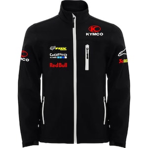 Può includere: Giacca nera con cerniera, cerniere bianche e vari loghi. I loghi includono KYMCO, FOX Racing, GoPro, Red Bull e Alpinestars. La giacca ha un collo alto e un design sportivo.