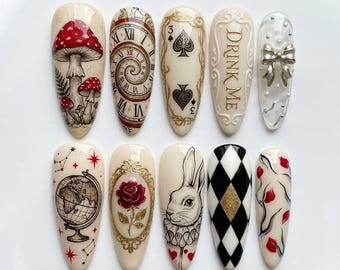 May include: A set of ten almond-shaped press-on nails featuring intricate designs including red mushrooms, a spiral clock face, playing card suits, the text DRINK ME, a silver bow, a globe, a red rose, a rabbit, black and white diamonds, and red petals.