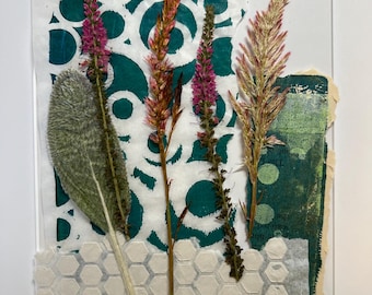 May include: A mixed media collage on a clear acrylic panel featuring pressed dried flowers, including pink and golden stalks and a fuzzy green leaf. The background consists of layered paper with teal circular patterns and a white honeycomb texture.