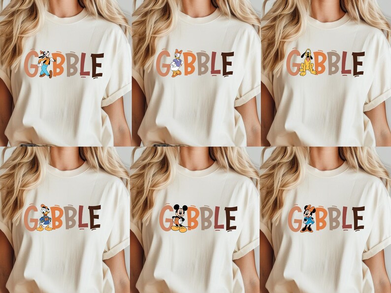 May include: Cream-colored t-shirts with the word "GOBBLE" in colorful letters. Each shirt features a different Disney character: Goofy, Daisy Duck, Pluto, Donald Duck, Mickey Mouse, and Minnie Mouse. The shirts are short-sleeved.
