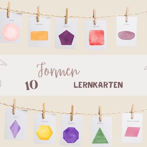 Peut inclure: Dix cartes de formes géométriques à l'aquarelle, dont un cercle, un rectangle, un pentagone, un carré et une ellipse, sont accrochées à une ficelle avec des pinces à linge. Les mots "Formen" et "Lernkarten" sont écrits sur l'image.