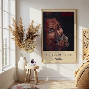 Puede incluir: Un póster de pared rectangular con la portada del álbum Fistful of Metal de Anthrax. El gráfico muestra a una persona con el puño envuelto en una cadena, detalles en rojo sangre y el nombre de la banda Anthrax en texto rojo y negro sobre fondo crema.
