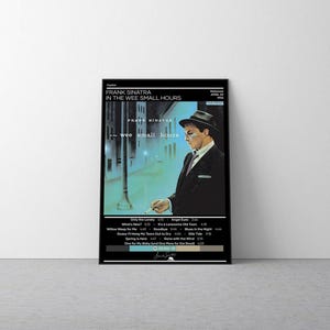 May include: A framed poster featuring the Frank Sinatra album In The Wee Small Hours. The artwork displays a man in a suit and fedora standing on a city street at night. Text includes the artist name, album title, tracklist, and release date.