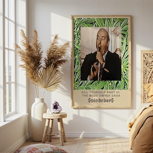 Puede incluir: Un póster enmarcado con un hombre con traje, rodeado de hojas de cannabis. El texto del póster dice: "KILL YOURSELF PART III: THE BUDD DWYER SAGA Suicideboys."