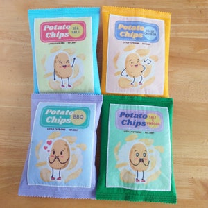 May include: Four colorful fabric pouches with potato chip designs. Each pouch features a cartoon potato chip character with different flavors: Sea Salt, Roast Chicken, BBQ, and Salt & Vinegar. The pouches are all labeled "Potato Chips" with the flavor listed below.