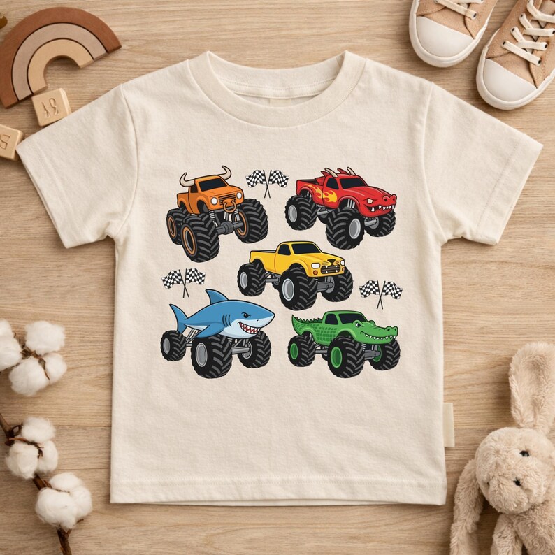 May include: Cream-coloured short-sleeved t-shirt with a graphic of five monster trucks. The trucks are orange, red, yellow, blue, and green, each with large black tyres and checkered flags. A fun design for children.
